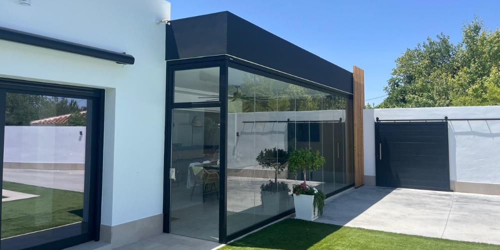 muebles de jardín debajo de un cerramiento de cristal totalmente protegidos durante todo el año