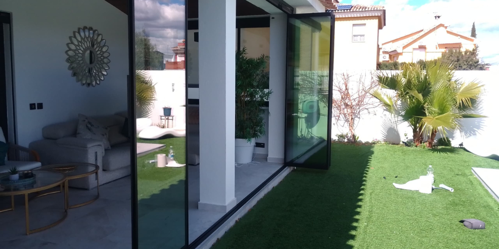muebles de jardín dentro de un cerramiento de cristal totalmente protegidos