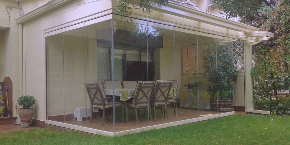 Cortina de cristal abatible si guía inferior en casa acogedora