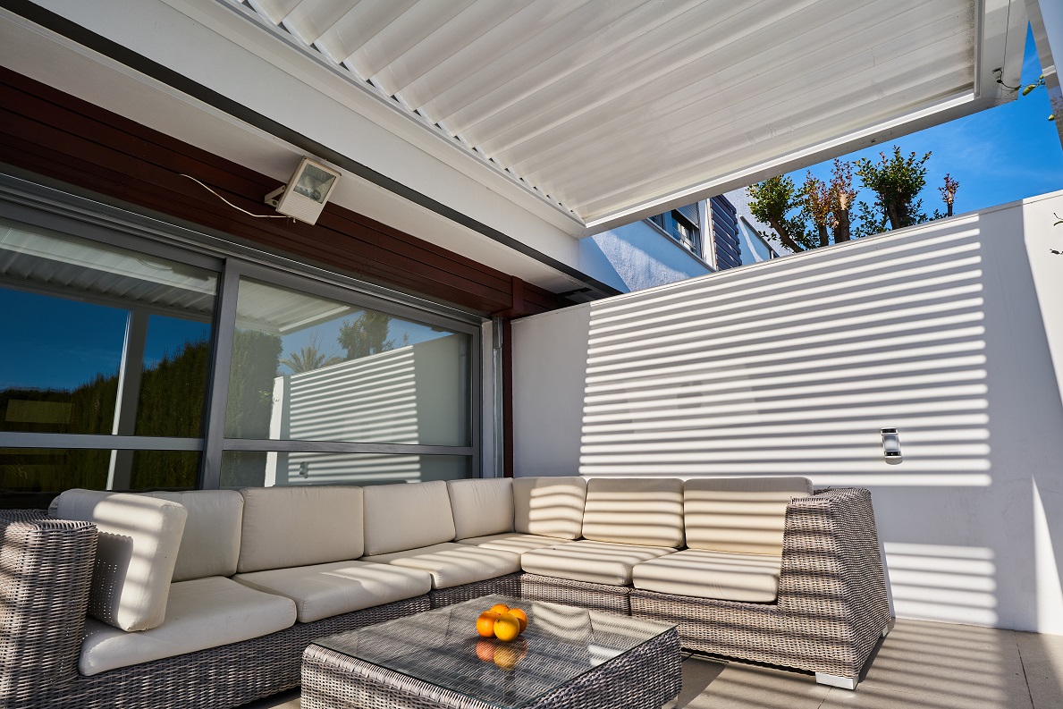 Pérgola bioclimática de lamas orientables abierta en un cerramiento de terraza