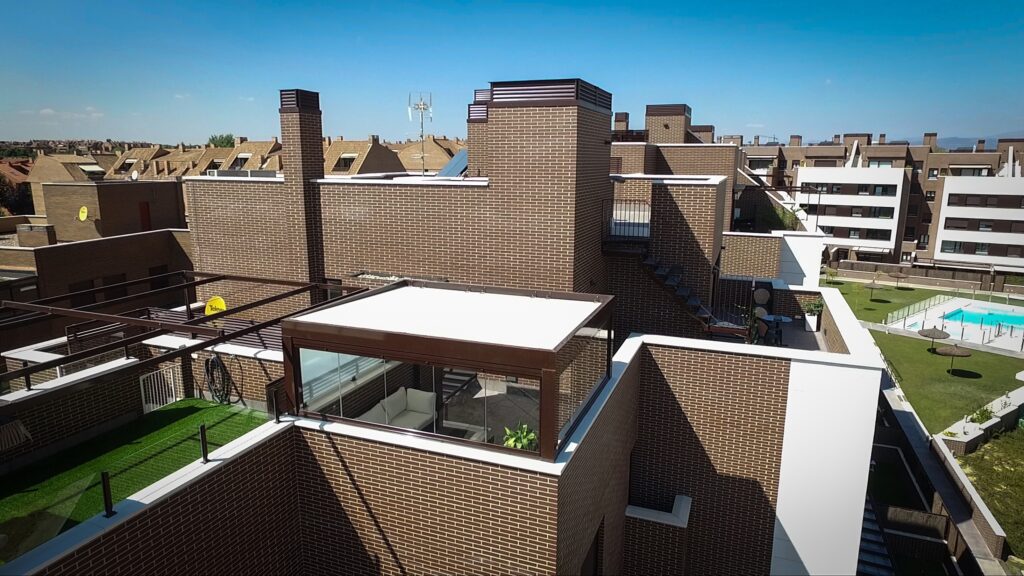 Cerramiento de pérgola de panel sándwich en terraza de comunidad de vecinos