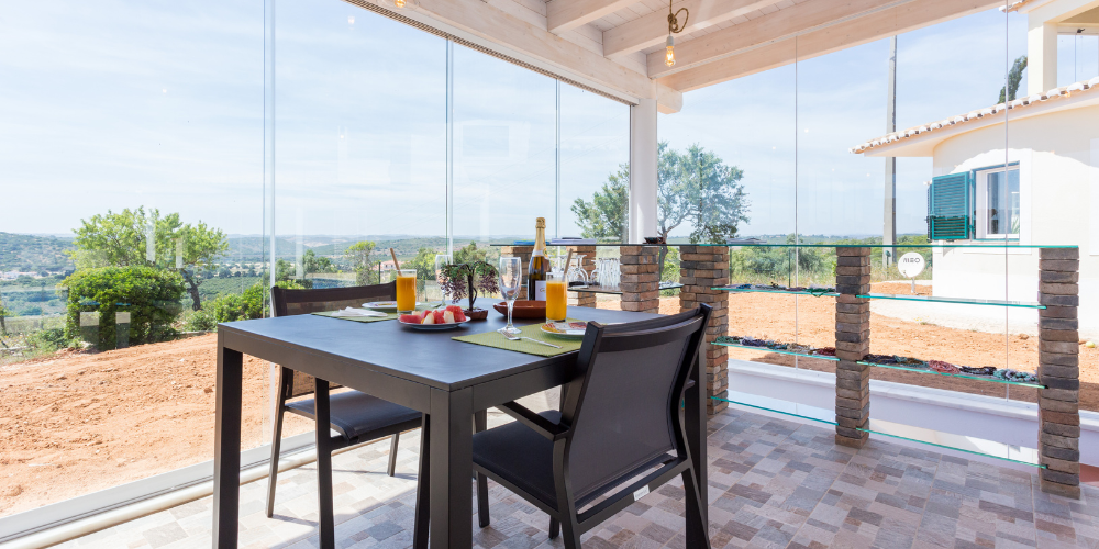 cerramiento de terraza donde podemos observar un desayuno preparado con las mejores vistas al exterior