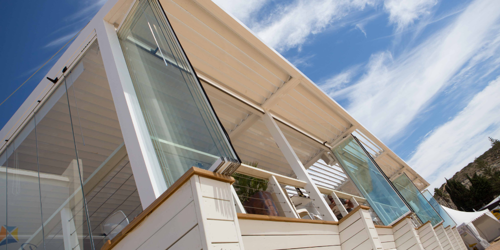Ejemplos de pérgolas bioclimáticas en hostelería con cortinas de cristal abatibles