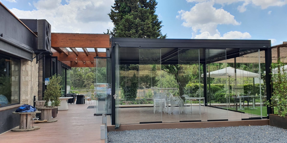 Ejemplos de pérgolas bioclimáticas en hostelería con cortinas de cristal abatibles