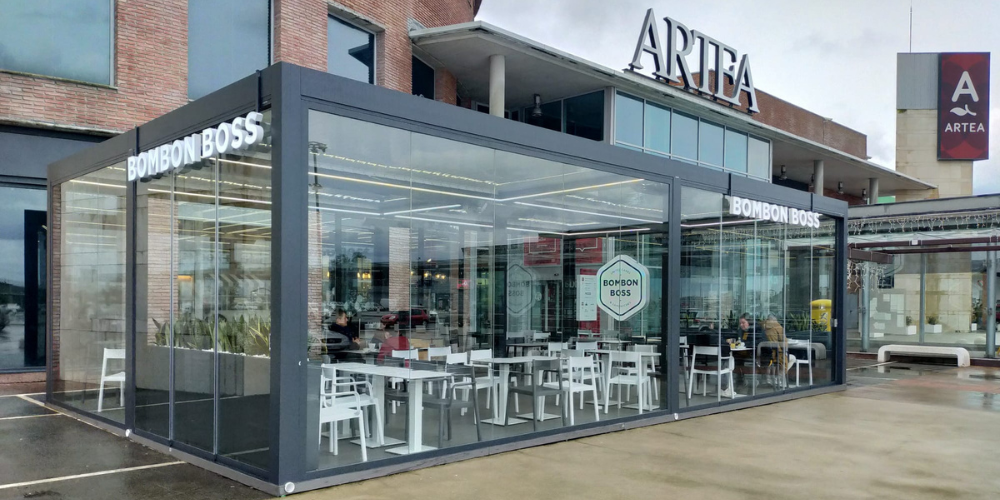 Ejemplos de pérgolas bioclimáticas en hostelería con cortinas de cristal correderas