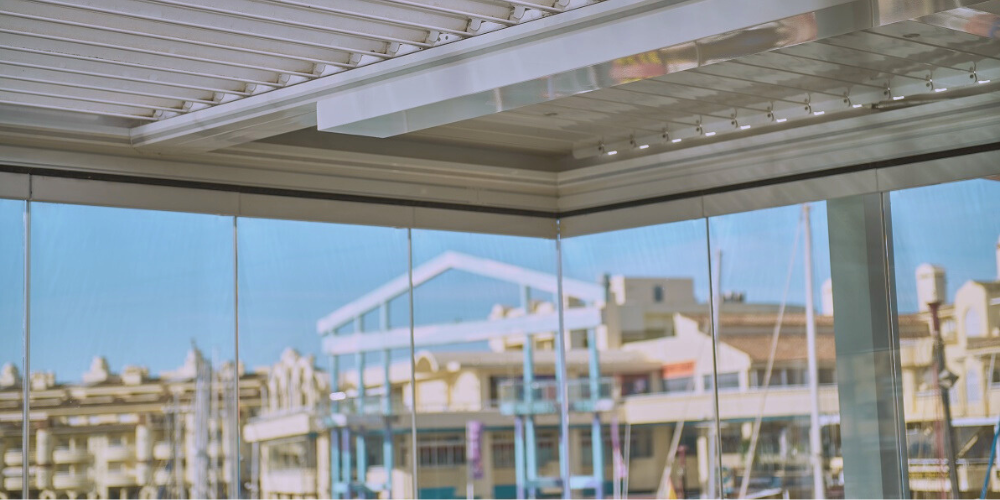 Ventajas de combinar pérgolas bioclimáticas con cortinas de cristal en hostelería