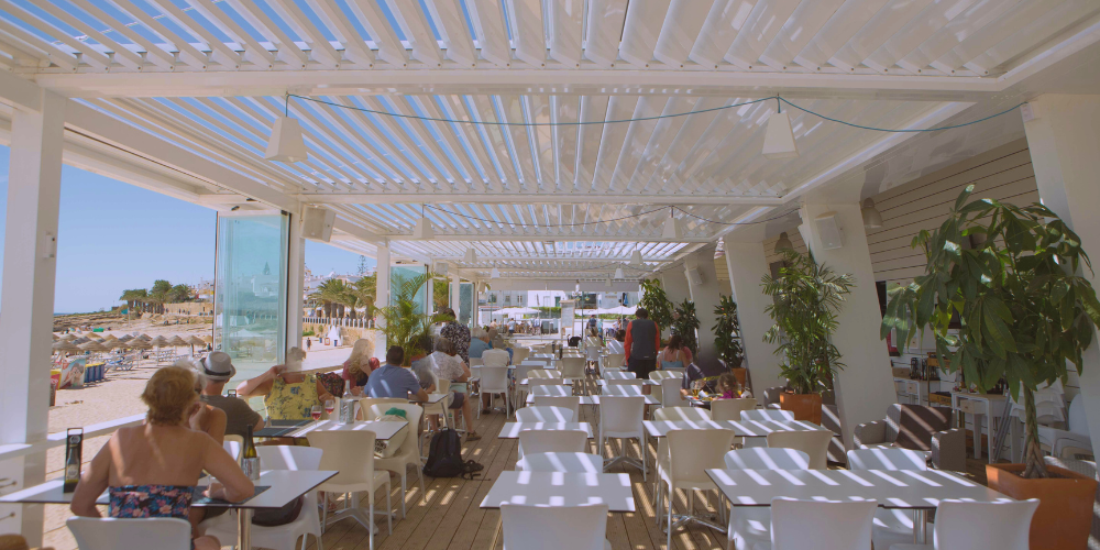 Ventajas de combinar pérgolas bioclimáticas con cortinas de cristal en hostelería