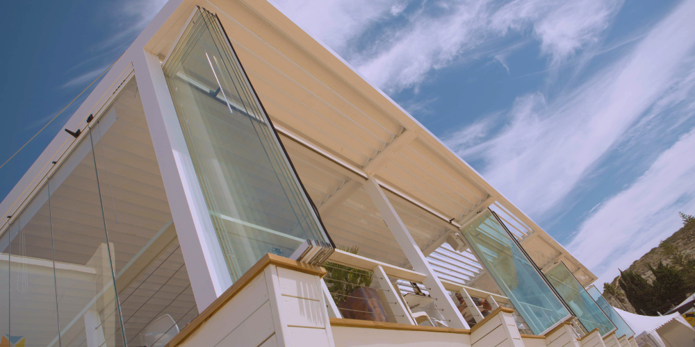 Ventajas de combinar pérgolas bioclimáticas con cortinas de cristal en hostelería