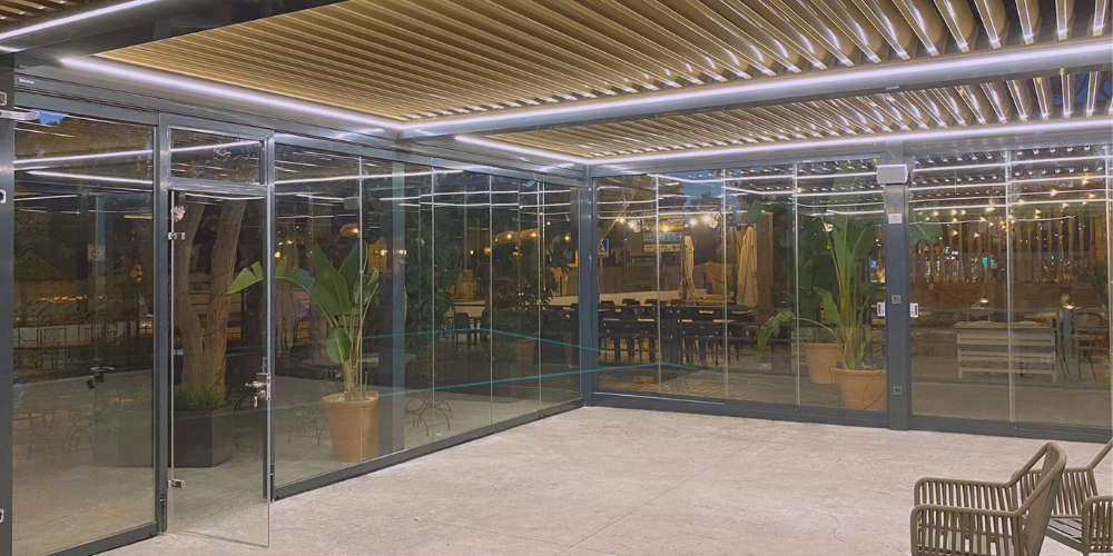 Ventajas de combinar pérgolas bioclimáticas con cortinas de cristal en hostelería